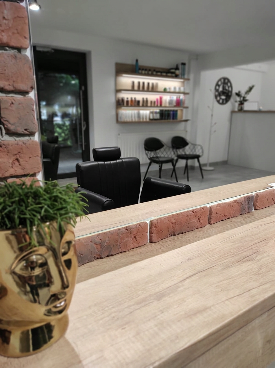 Recepcja salonu Perfect Beauty z drewnianym blatem i złotą doniczką
